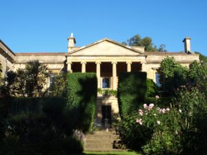 Batsford Arboretum is a classic pillared building with thick green bushes and dog friendly gardens.